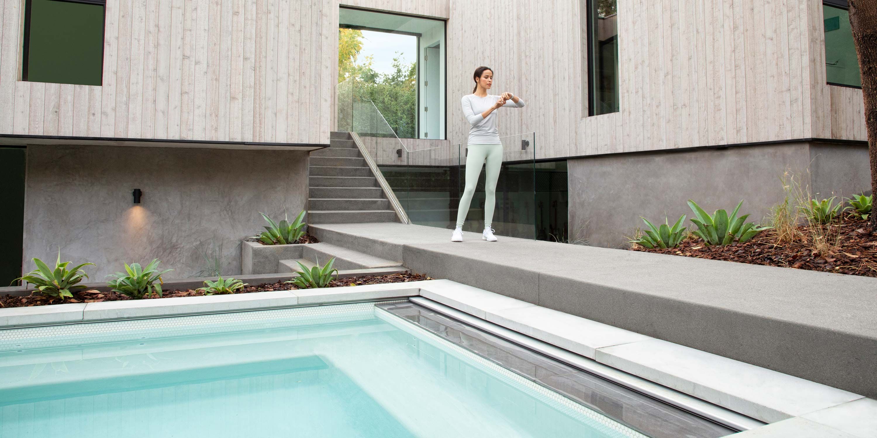 woman checking her watch outside by the pool